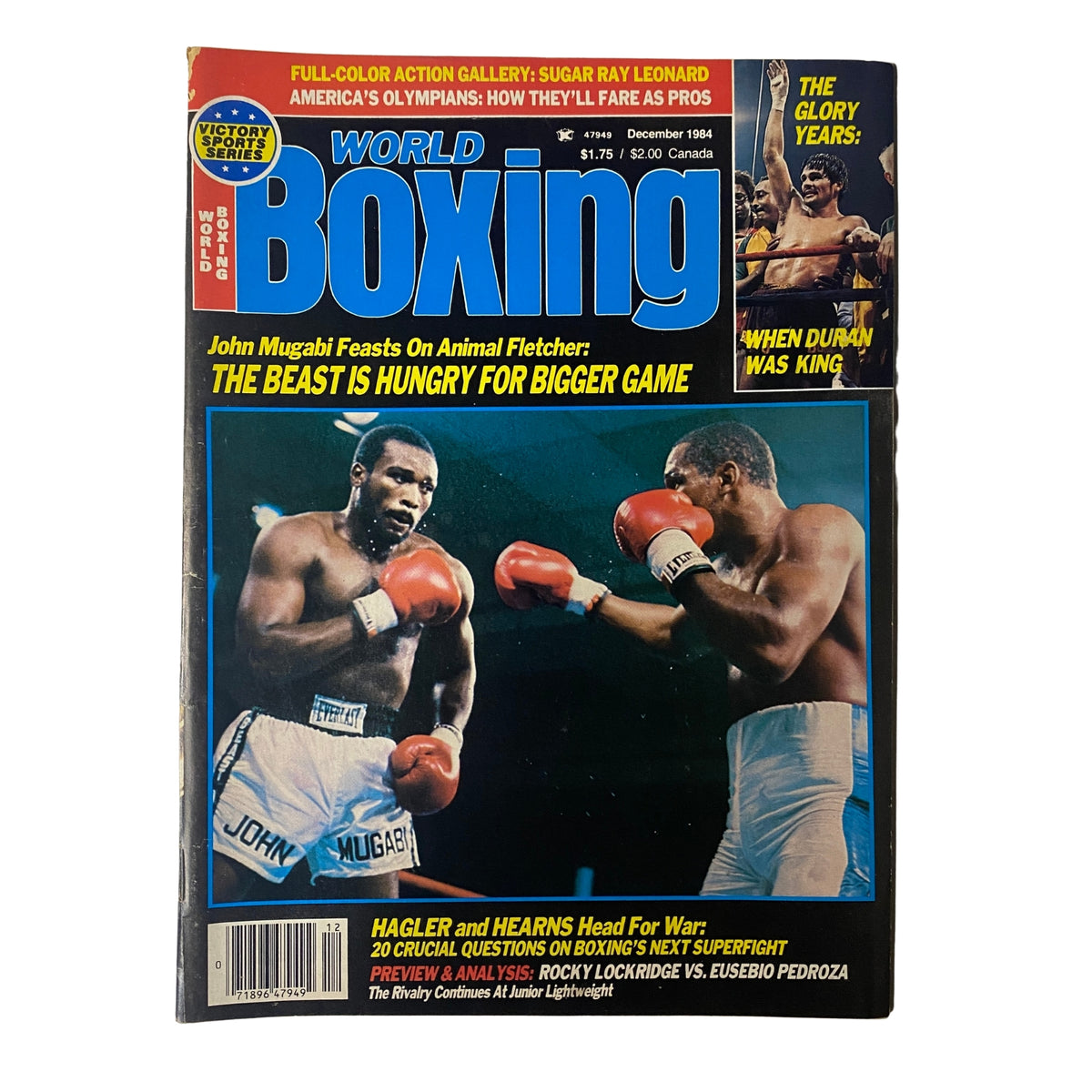 Cover of World Boxing Magazine December 1984 featuring John Mugabi, highlighting his victory over Animal Fletcher with the caption 'The Beast is Hungry for Bigger Game'. Includes mentions of marquee matchups like Hagler vs. Hearns and coverage of America's Olympians transitioning to professional boxing.