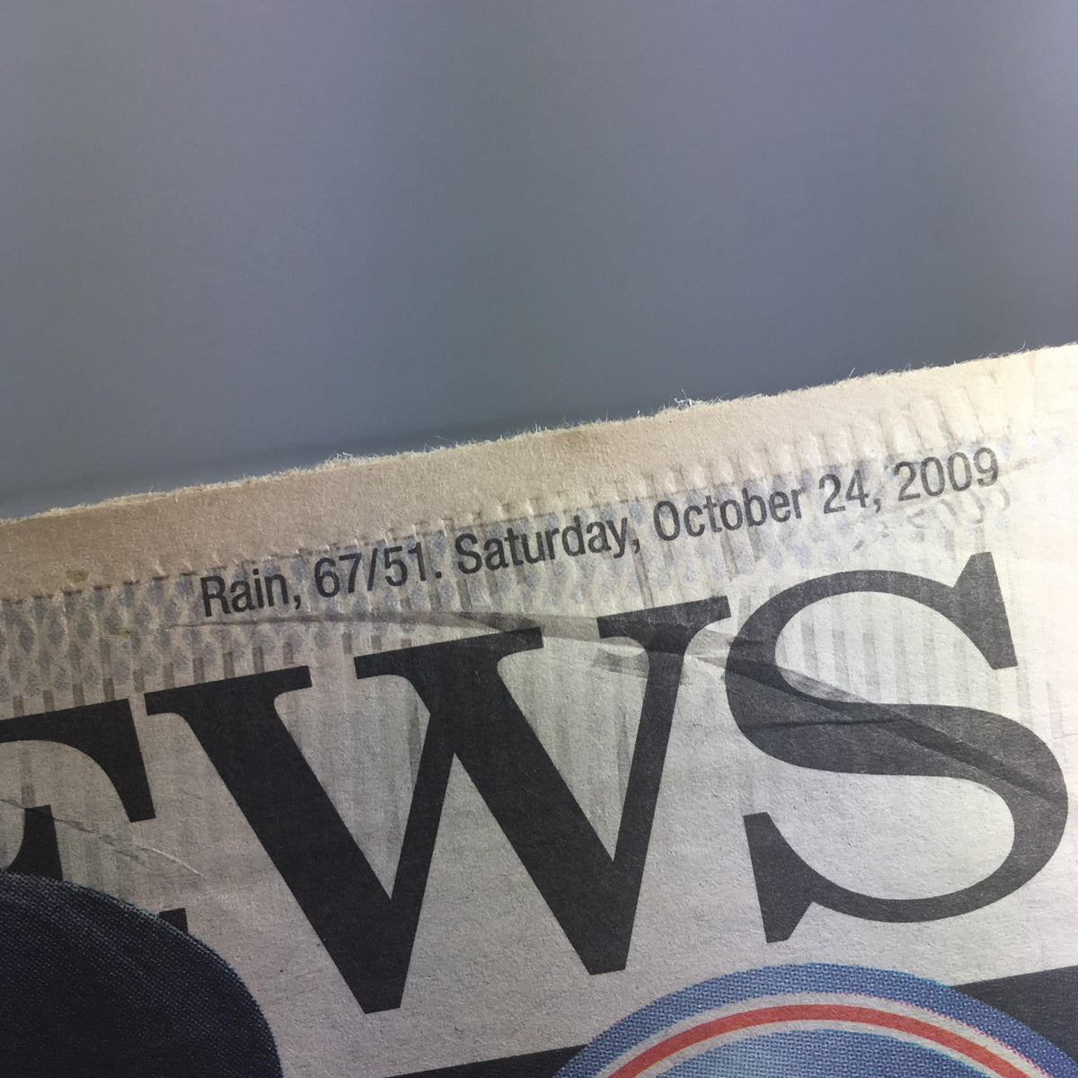 Close-up of NY Daily News headline dated October 24, 2009, mentioning weather report—Rain, 67°/51°.