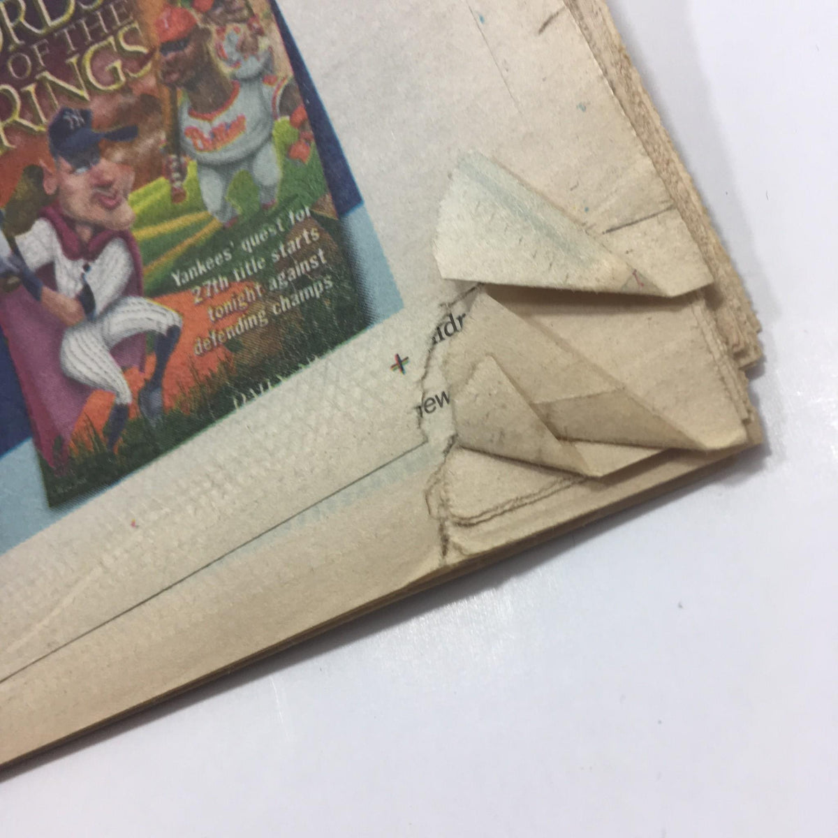 Close-up of corner damage on NY Daily News from October 28, 2009, related to the article 'It'll Be Heaven When Yanks Win 27', revealing aging sign.
