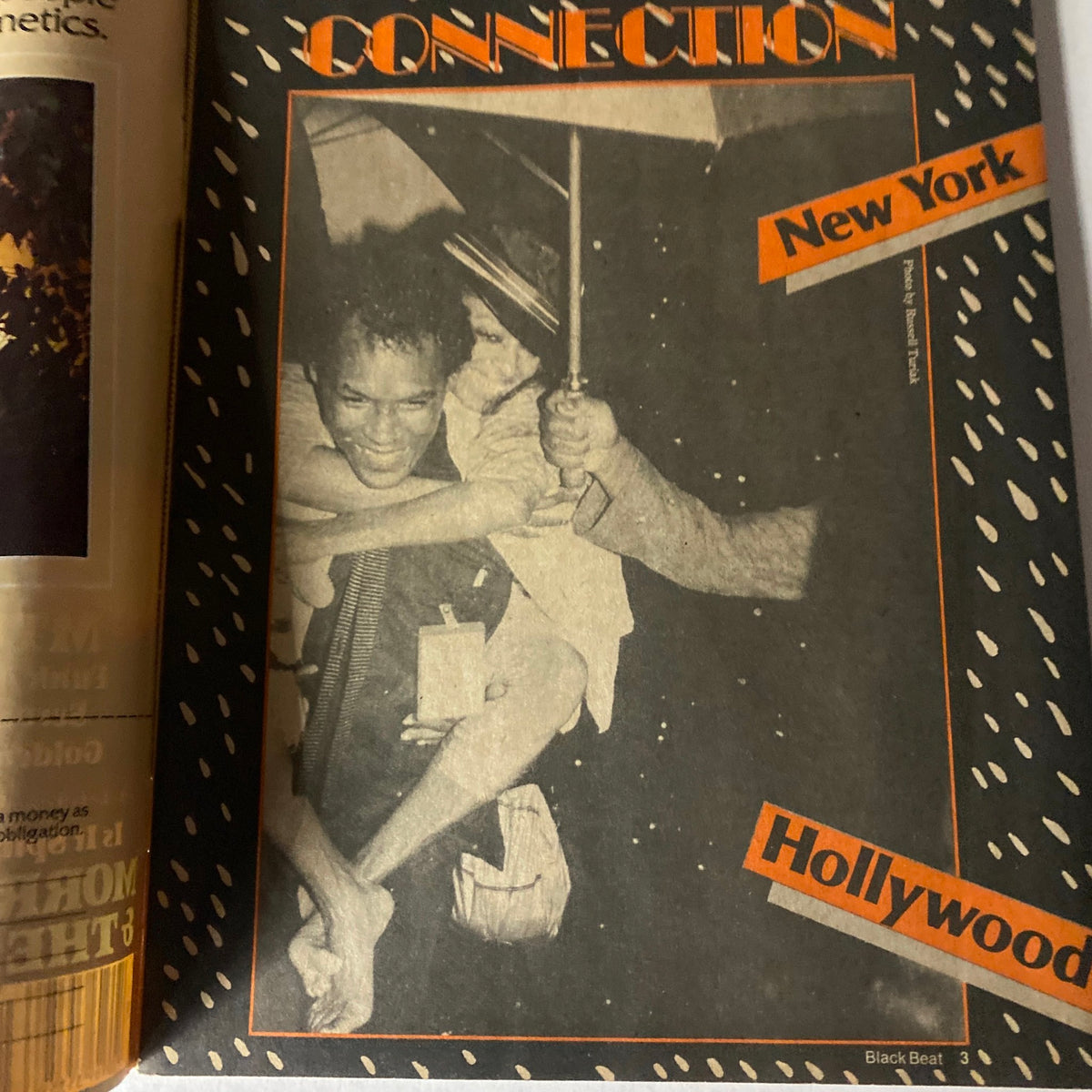 Cover image of the VTG Black Beat Magazine December 1983 featuring a candid moment with people under an umbrella, highlighting the connection between New York and Hollywood.