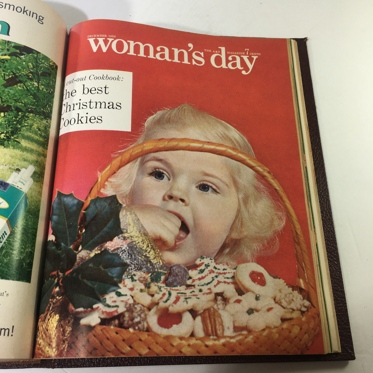 Cover image of the 1956 Woman's Day Magazine featuring a child with a basket of cookies, highlighting festive holiday themes.