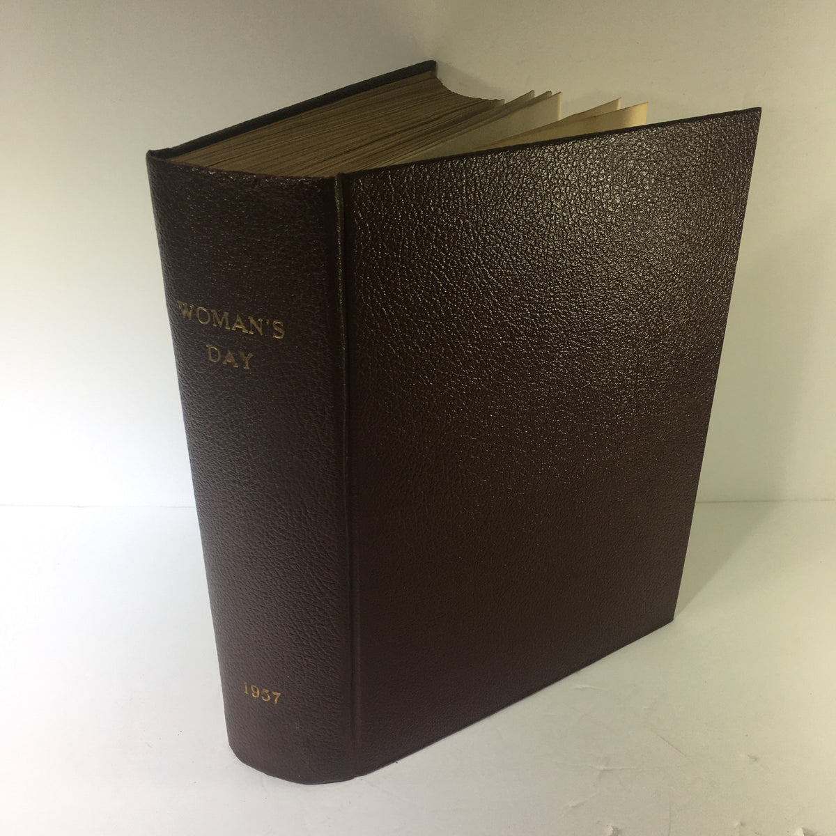 Side view of the 1957 Woman's Day Magazine compilation, featuring embossed title and year on the spine, ideal for vintage magazine collectors.