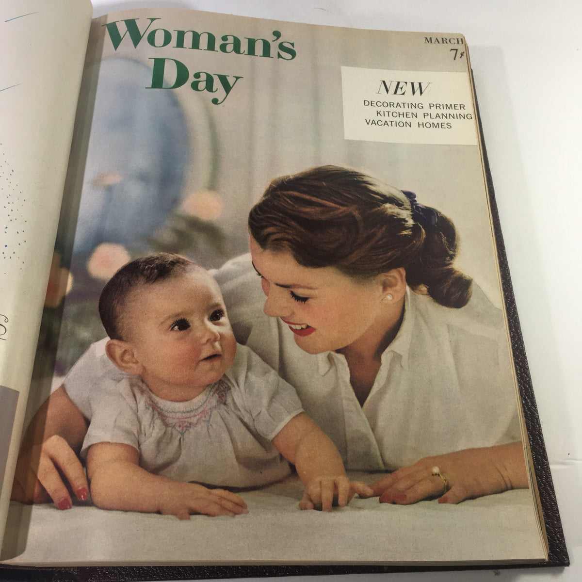 March 1957 cover of Woman's Day Magazine depicting a mother with her baby, highlighting topics like decorating and kitchen planning.