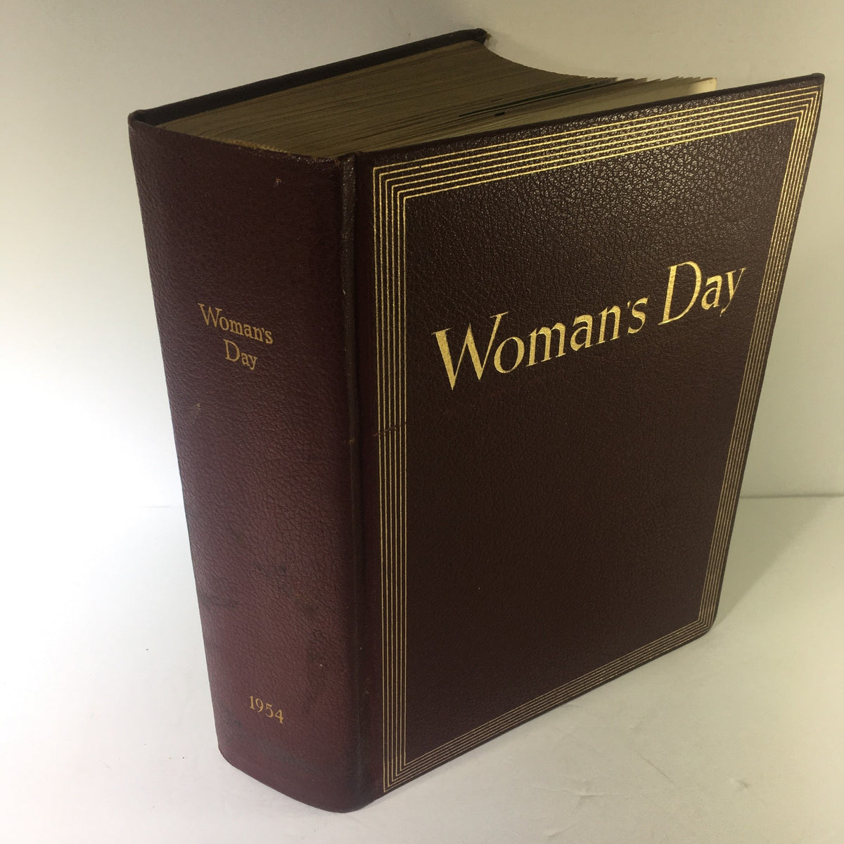 1954 Woman's Day Magazine Complete Year Round In One Book Compilation, showcasing the vintage cover with embossed gold lettering for 'Woman's Day' and the year, reflecting its classic design in good condition.