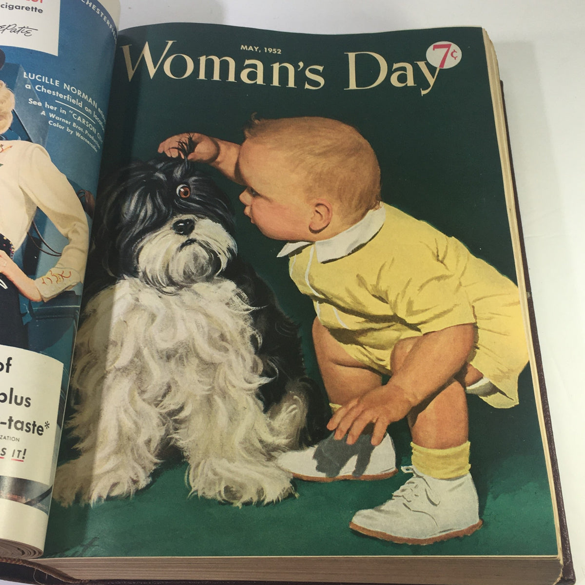 Cover page of May 1952 issue from the 1952 Woman's Day Magazine Complete Year Round In One Book Compilation, depicting a toddler interacting with a dog, capturing childhood innocence.