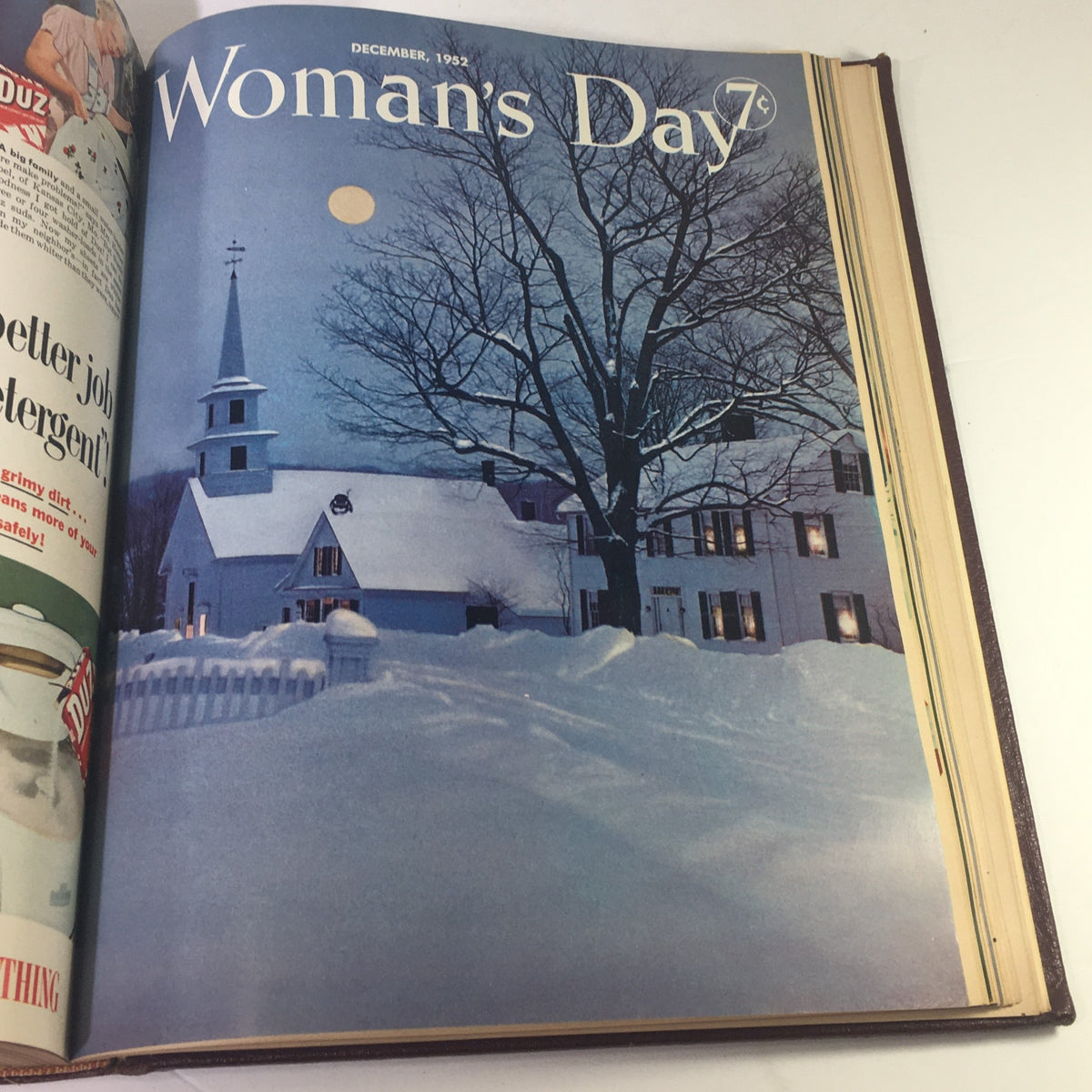 Cover of the December 1952 Woman's Day Magazine depicting a serene winter scene with a snow-covered church, reflecting the serene beauty of the holiday season.