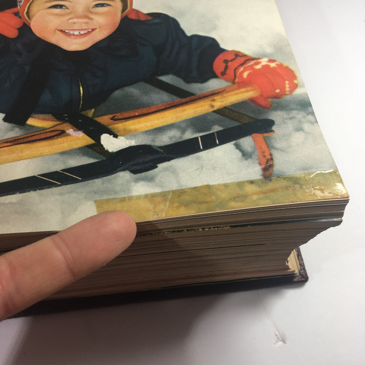 Detail of the January 1951 issue cover of Woman's Day Magazine highlighting a child's smile and vintage winter fashion.