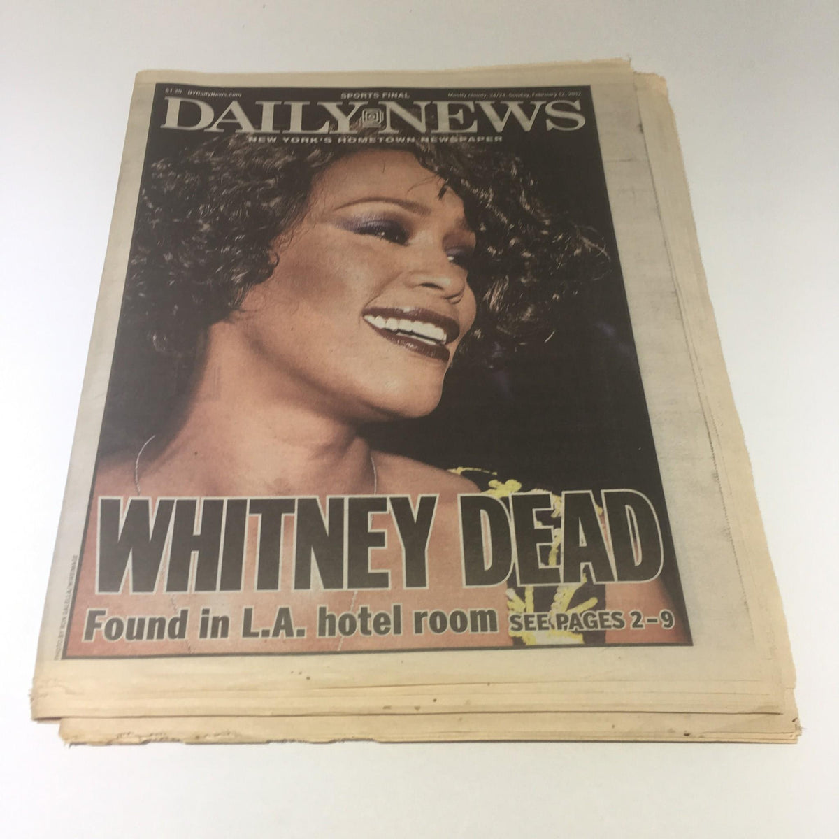 New York Daily News front page from February 12, 2012, featuring the headline 'Whitney Dead Found in L.A. hotel room'. The newspaper highlights the tragic news of Whitney Houston's passing, showcasing a prominent photo of the singer.