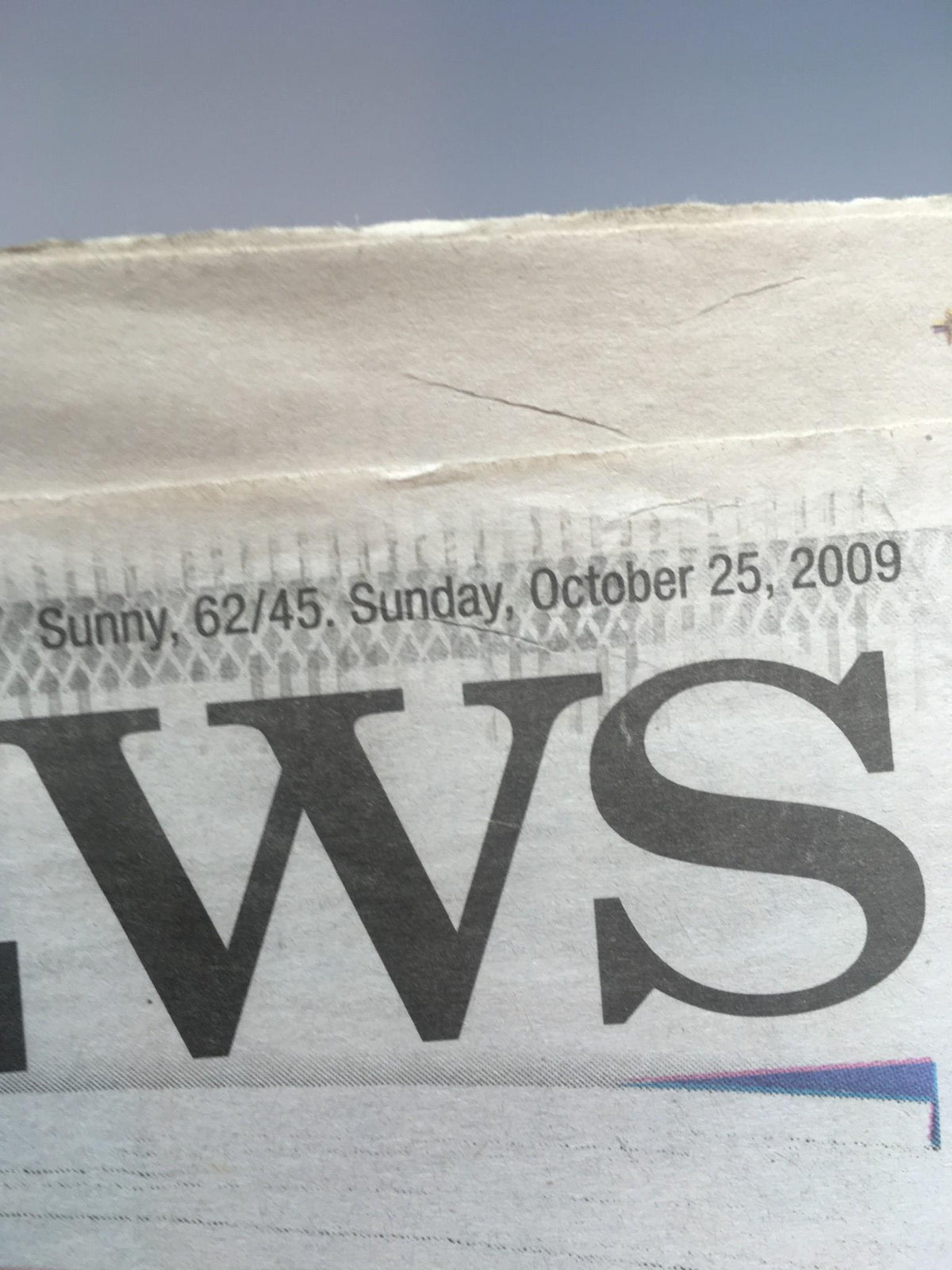 Close-up of the date section of the New York Daily News from October 25, 2009, indicating sunny weather and temperatures.
