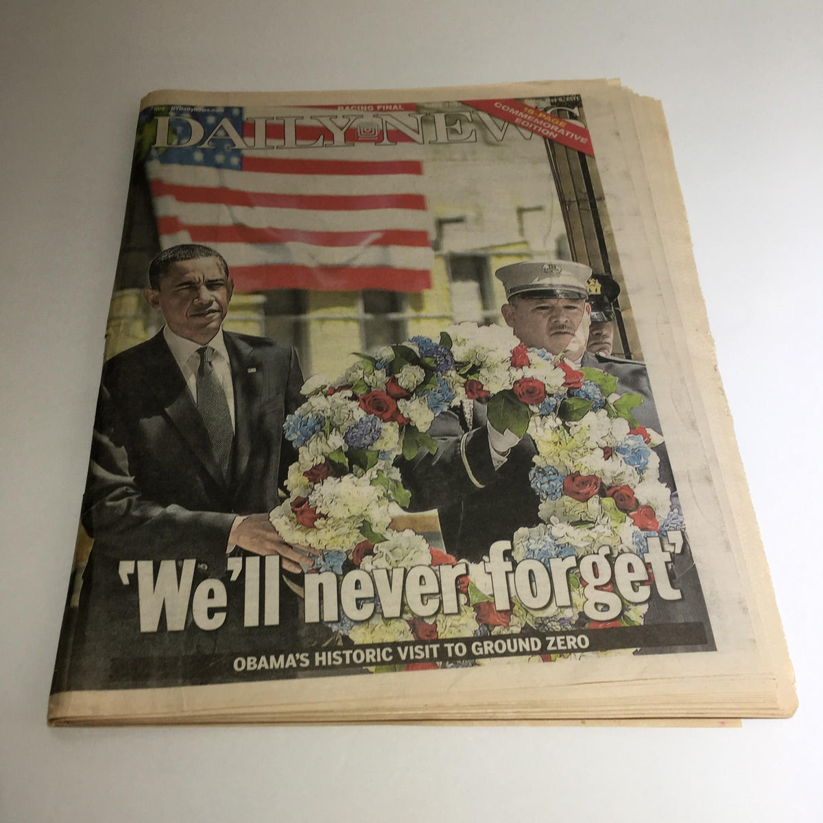 Front page of NY Daily News, dated May 6, 2011, highlighting Obama's historic visit to Ground Zero with the title 'We'll never forget' and a photo of Obama and a service member presenting a floral wreath.