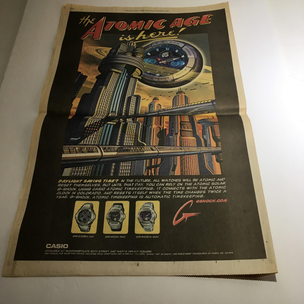 Vintage advertisement from The New York Times, October 28, 2004, featuring a futuristic watch with the tagline "The Atomic Age is here."