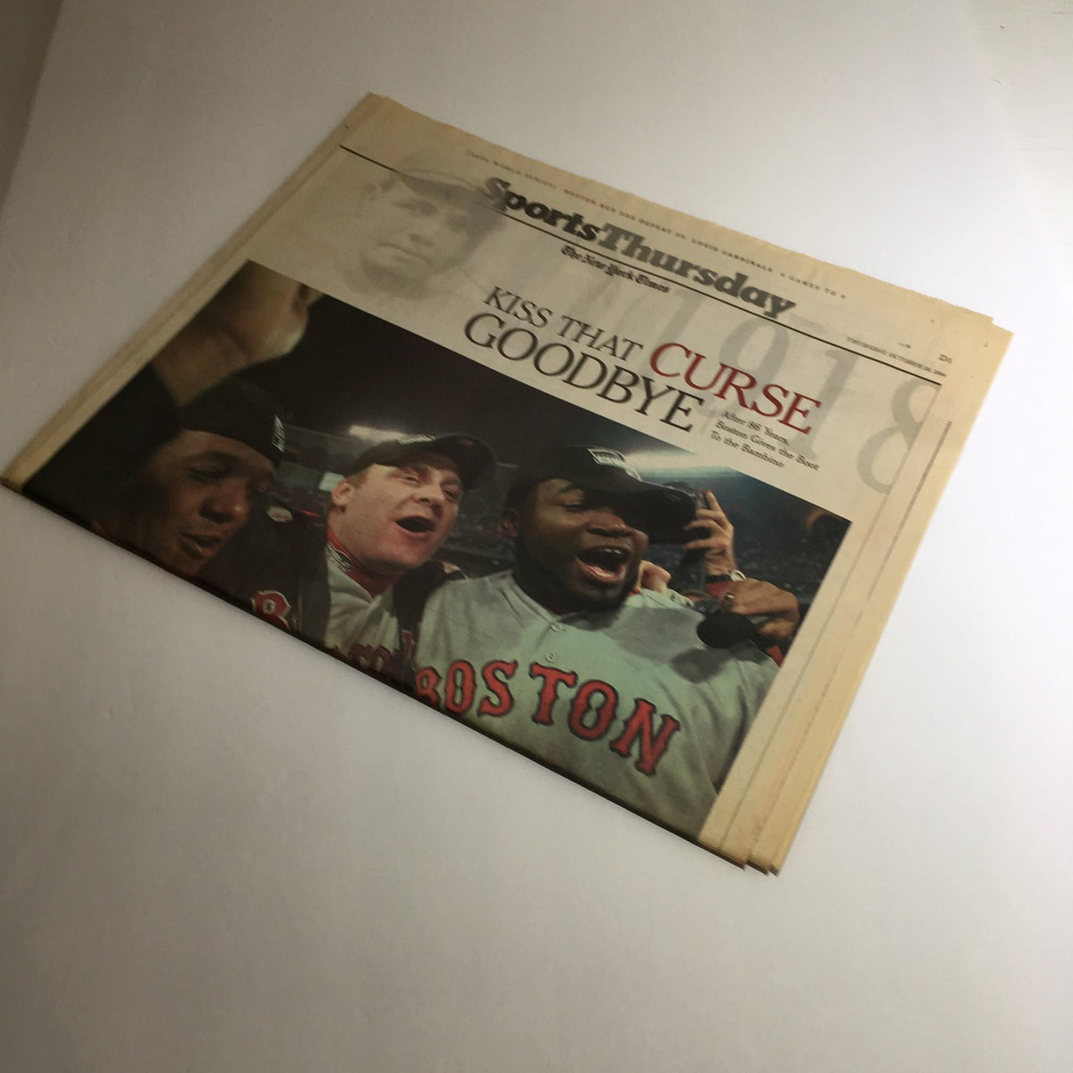 Another view of The New York Times October 28, 2004 cover highlighting the celebratory headline "Kiss That Curse Goodbye" related to the Boston Red Sox.