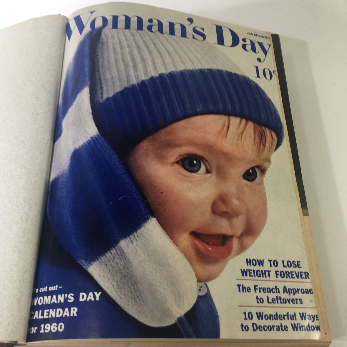 1960 Woman's Day Magazine January issue featuring a baby in a blue striped hat on the cover.