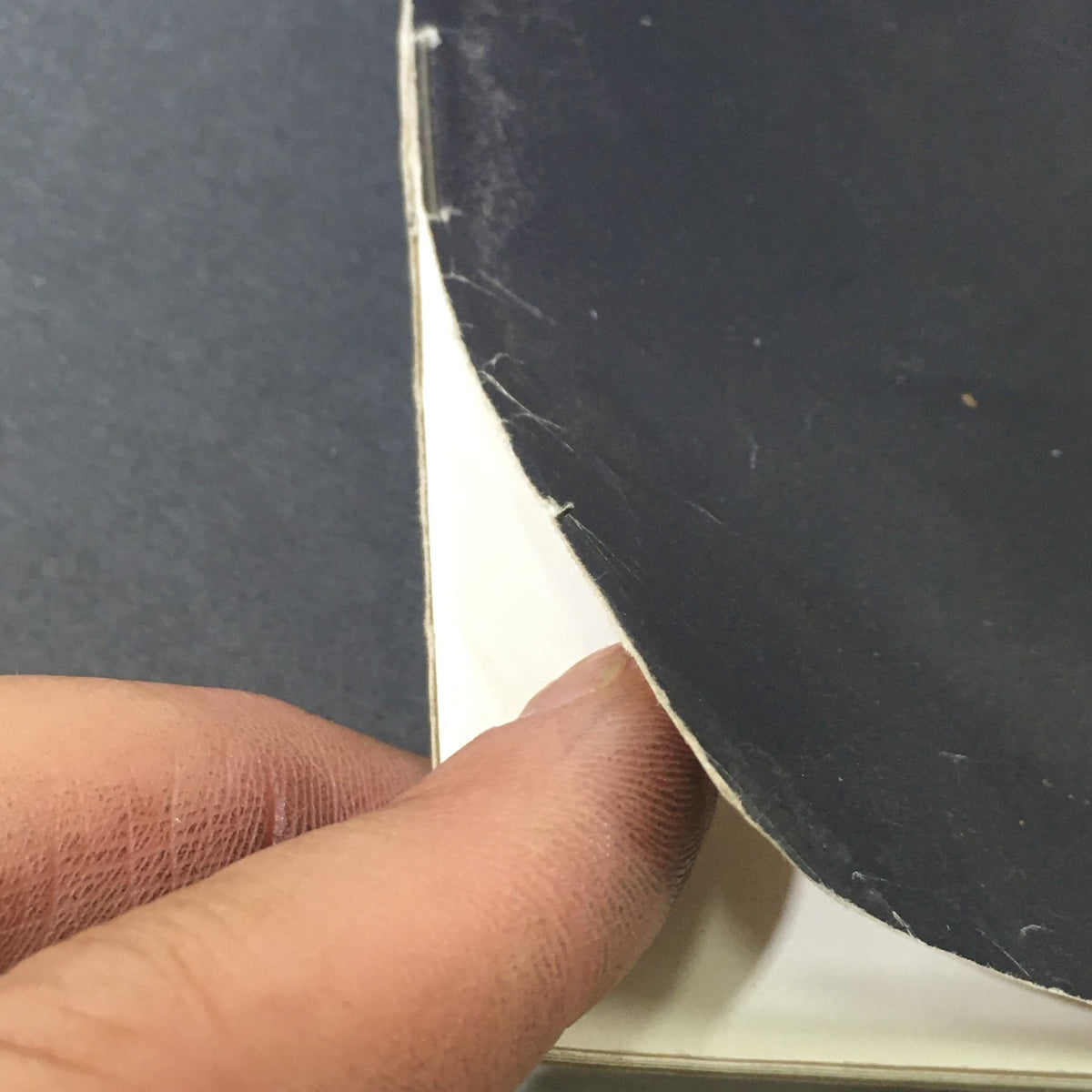 Close-up of the spine of a vintage magazine, The Saturday Evening Post February 10 1968, showing wear and a finger holding the edge.