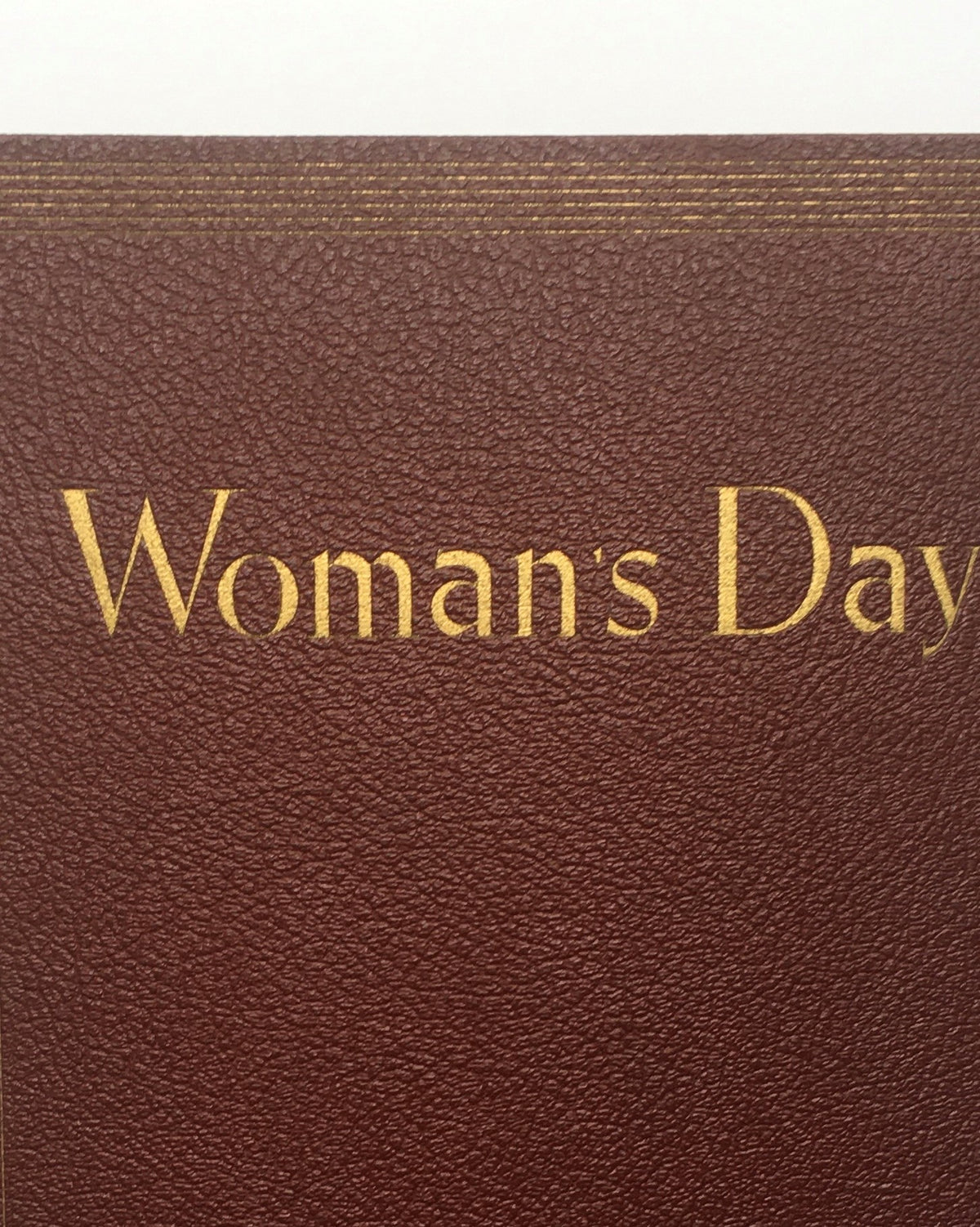 Close-up view of the cover of the 1941 Woman's Day Magazine Compilation with embossed golden lettering.