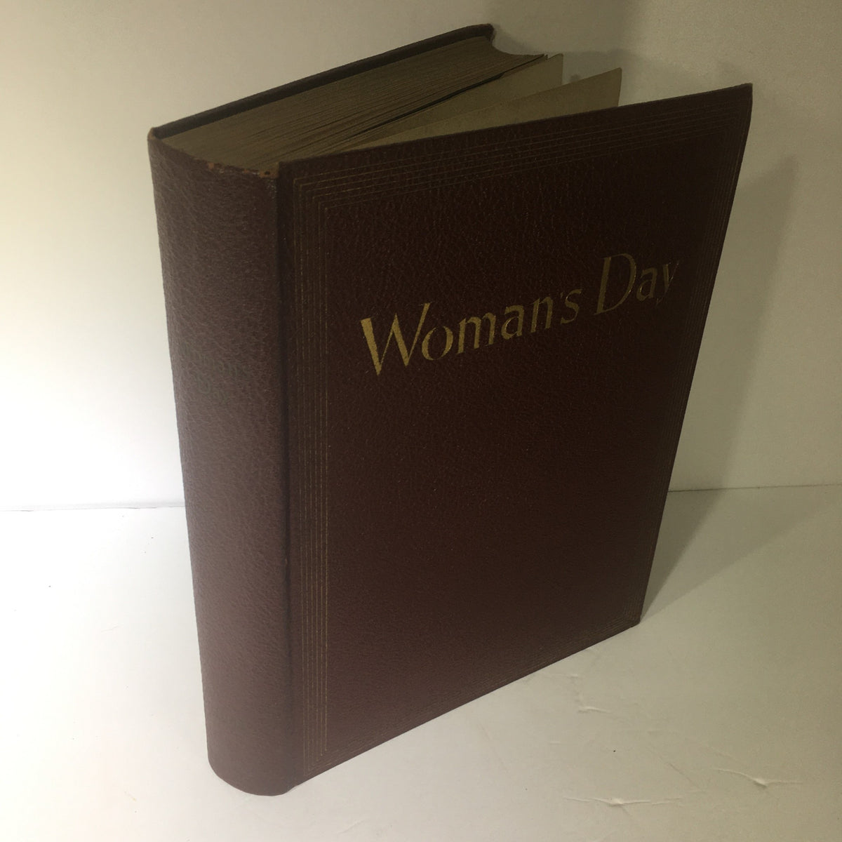 Side angle of the 1941 Woman's Day Magazine Compilation, showcasing its vintage brown cover and gold title.