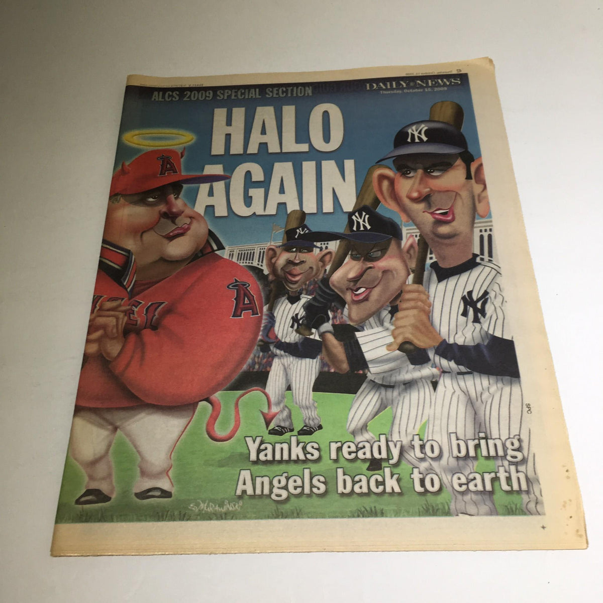 Cover of NY Daily News from October 15, 2009 titled 'Halo Again: Yanks Ready to Bring Angels Back to Earth' featuring caricatures of baseball players including Yankees and Angels.