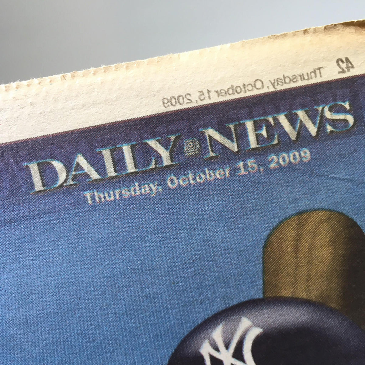 Top header of NY Daily News dated Thursday, October 15, 2009, part of the cover featuring a blue background and a baseball bat.