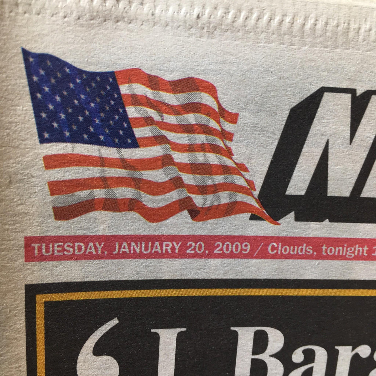 Close-up of the New York Post dated January 20, 2009, showing the American flag alongside the headline 'Barack Hussein Obama Pledge, America's Historic Day'.