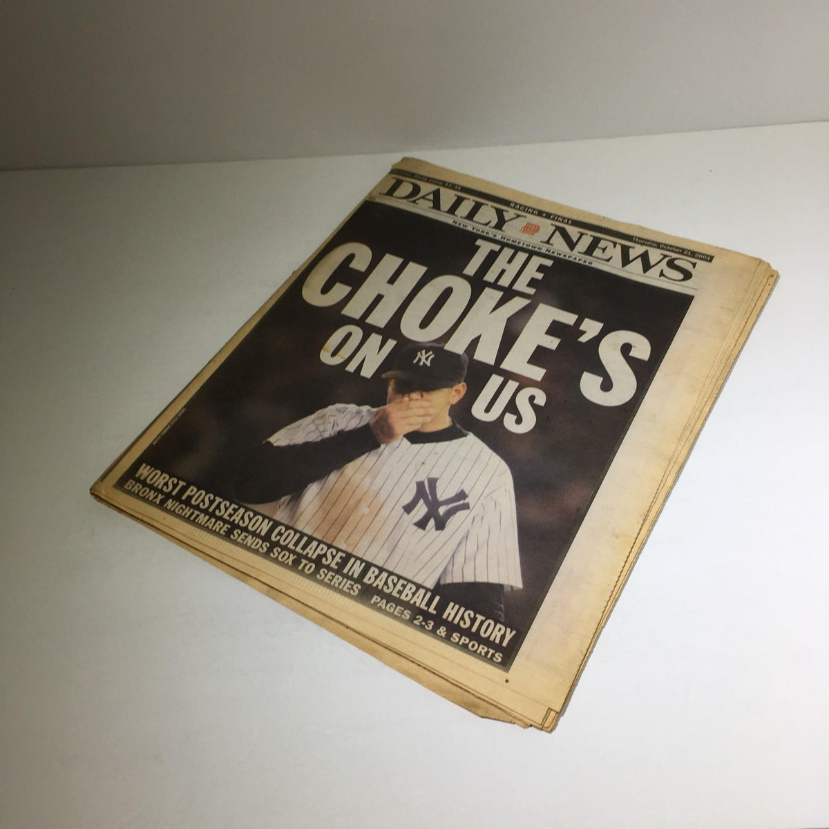 Another angle of the New York Daily News cover displaying 'The Choke's on US', focusing on the worst postseason collapse in baseball history.