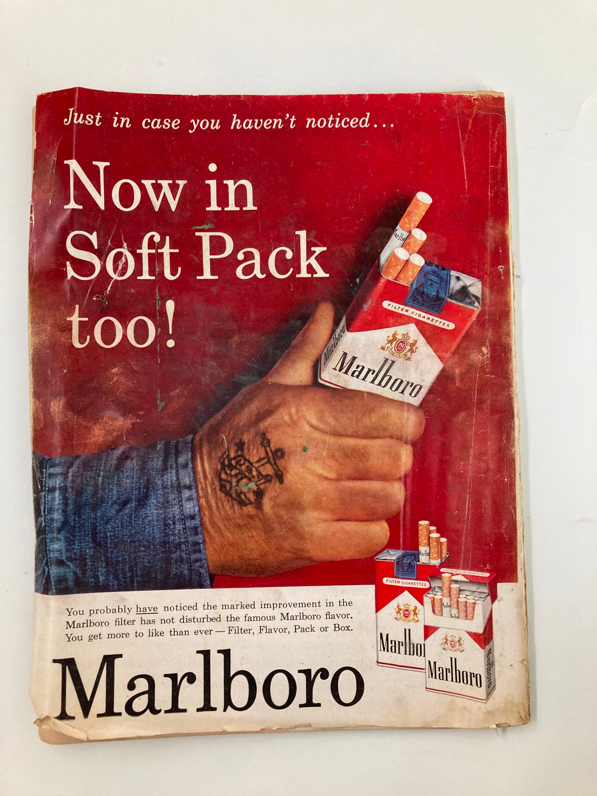 Advertisement from TRUE The Man's Magazine November 1958 for Marlboro cigarettes, highlighting the product's new soft pack design against a vibrant red background, reflecting popular advertising trends of the era.