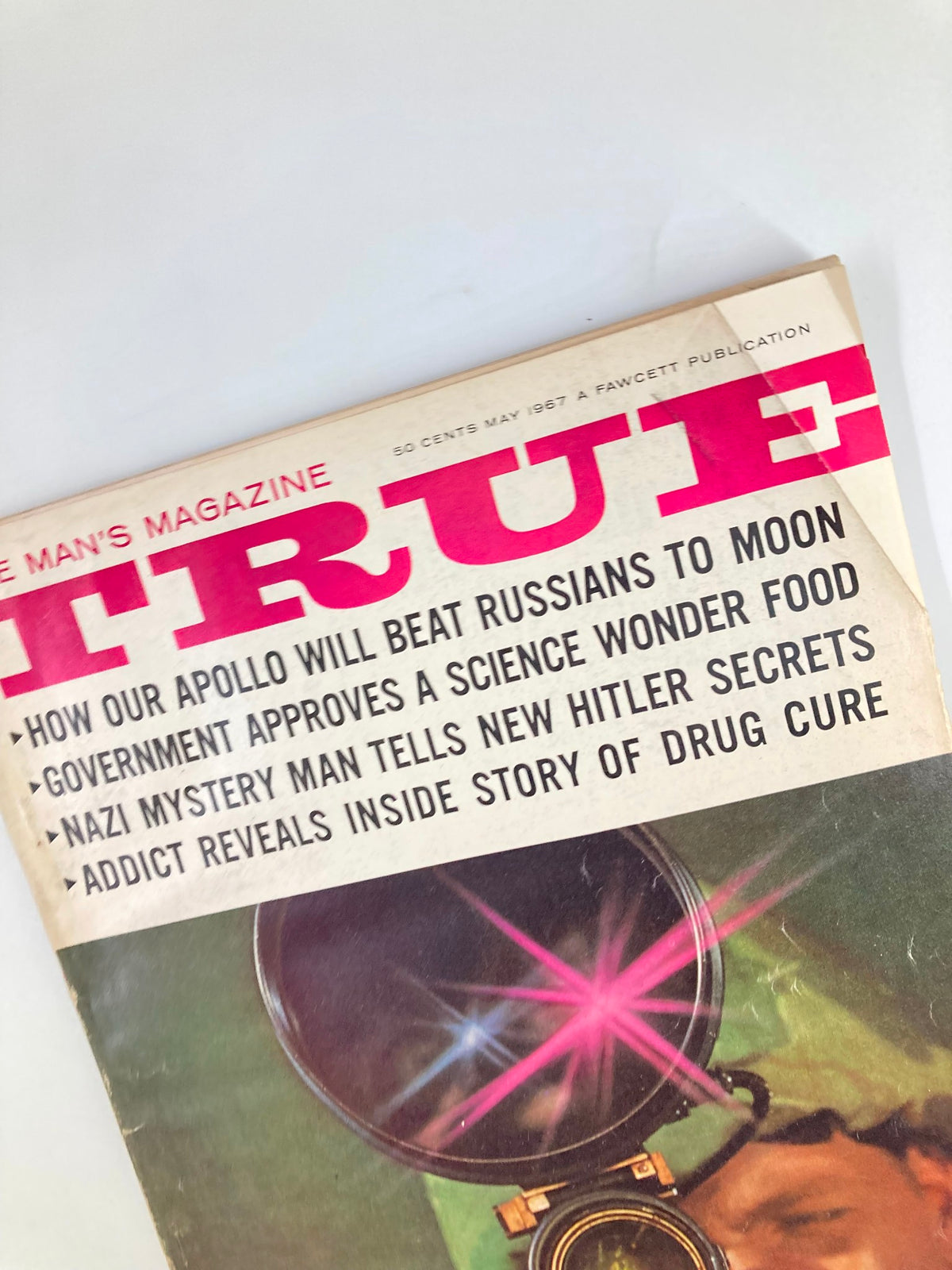 Close-up of the cover of TRUE The Man's Magazine May 1967 emphasizing article titles including 'How Our Apollo Will Beat Russians to Moon' and 'Government Approves a Science Wonder Food'.