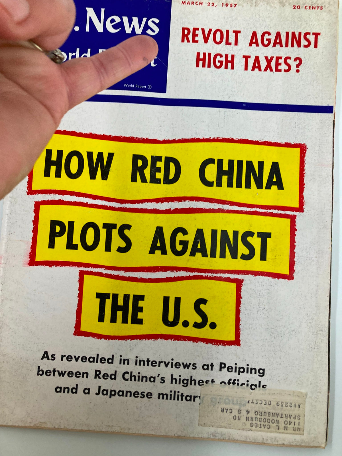 Cover of US News & World Report Magazine from March 22, 1957, showing the title 'Revolt Against High Taxes?' with emphasis on Red China's strategies against the United States, hand pointing at the title.