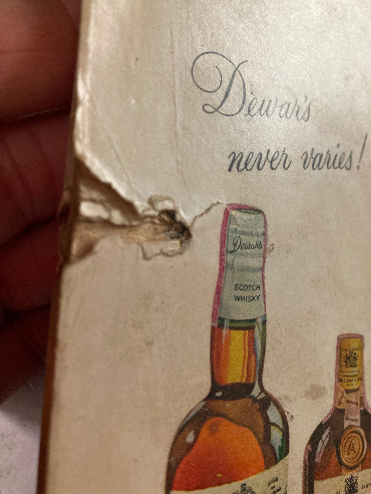 Close-up image showing damage on the back cover of TRUE The Man's Magazine December 1958, featuring an advertisement for Dewar's Scotch Whisky.