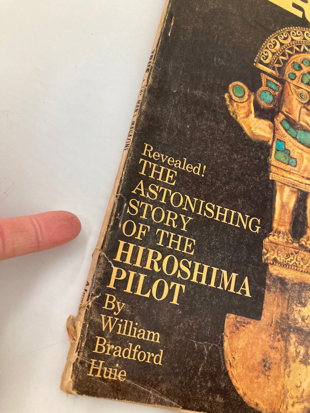 Close-up of the cover of TRUE The Man's Magazine March 1964, highlighting the headline 'The Astonishing Story of the Hiroshima Pilot' by William Bradford Huie along with visible signs of wear, reflecting its vintage quality.