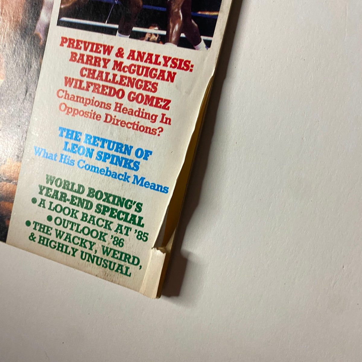 Close-up of World Boxing Magazine April 1986 cover details, highlighting feature articles such as 'Preview & Analysis' on Barry McGuigan and commentary on Leon Spinks' comeback.