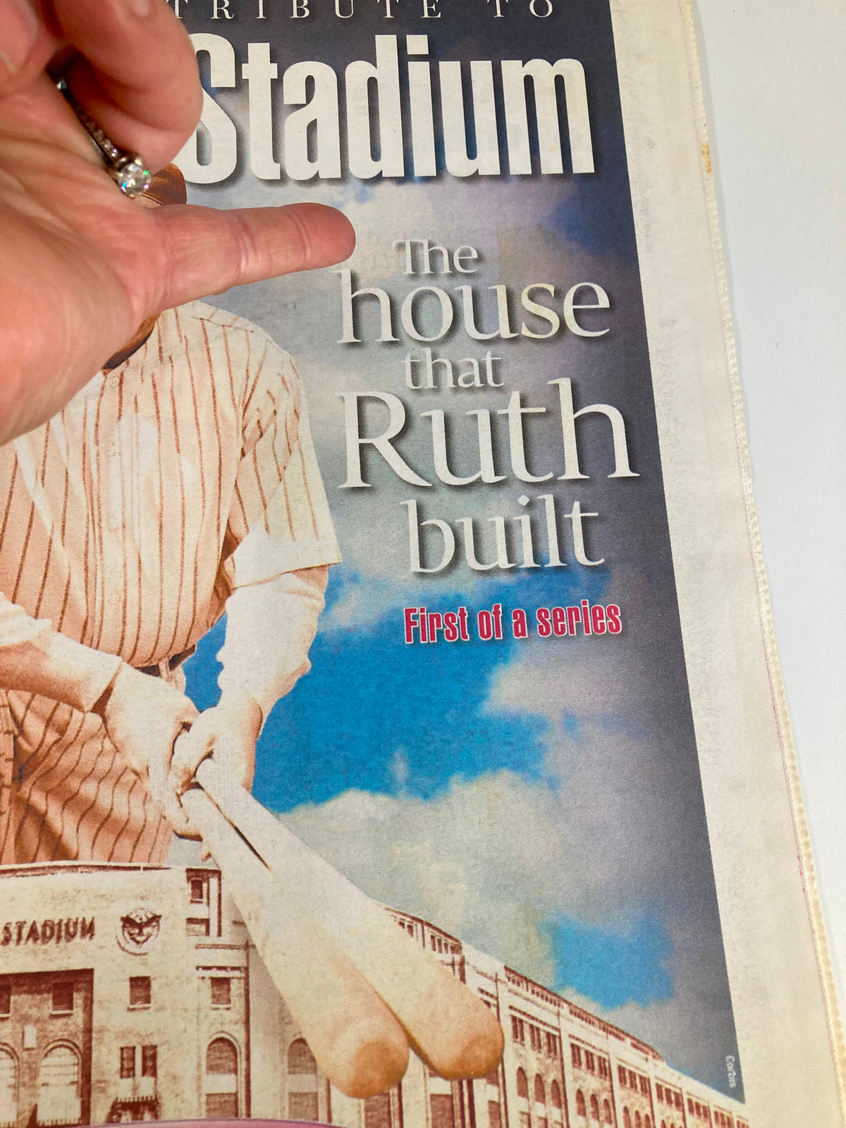Close-up of the New York Post souvenir tribute cover 'The House That Babe Ruth Built,' showing Babe Ruth holding a bat with a hand pointing towards the text.
