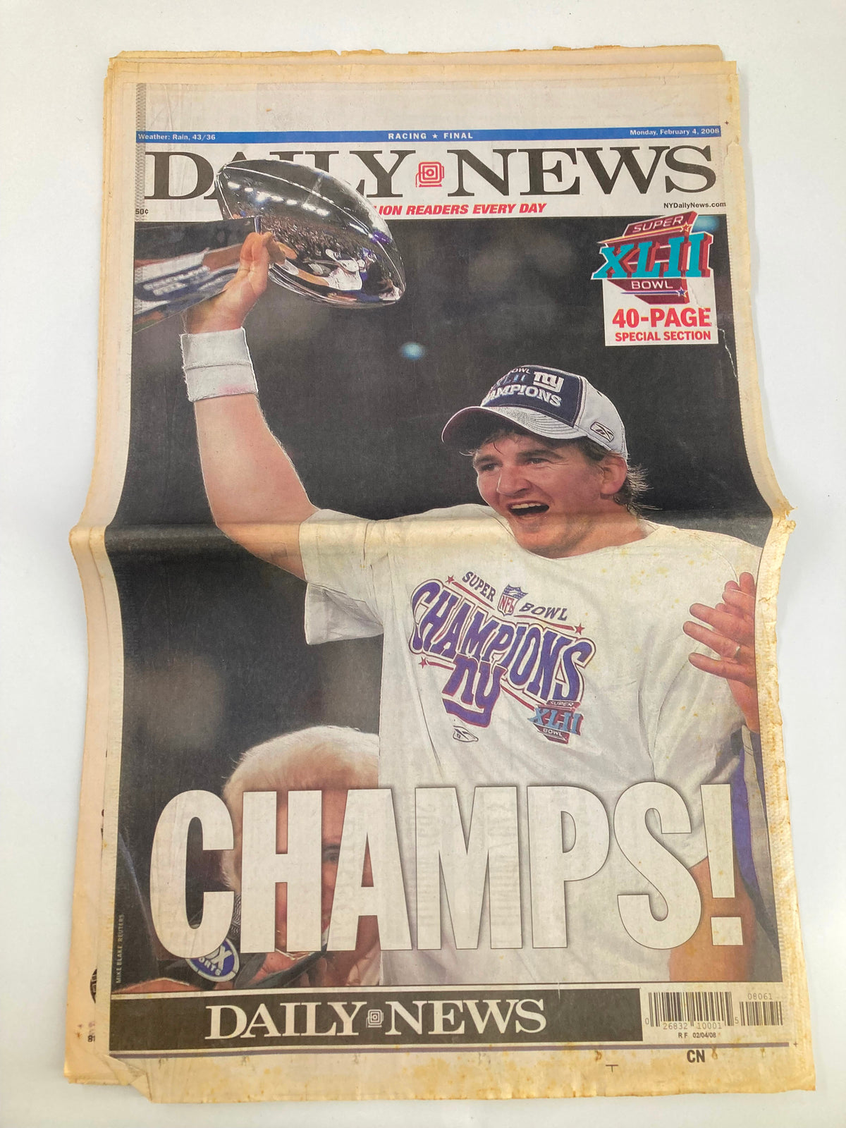 Daily News Newspaper February 4 2008 celebrating New York Giants Super Bowl Champions with a jubilant player holding the championship trophy and a vibrant 'CHAMPS!' headline.