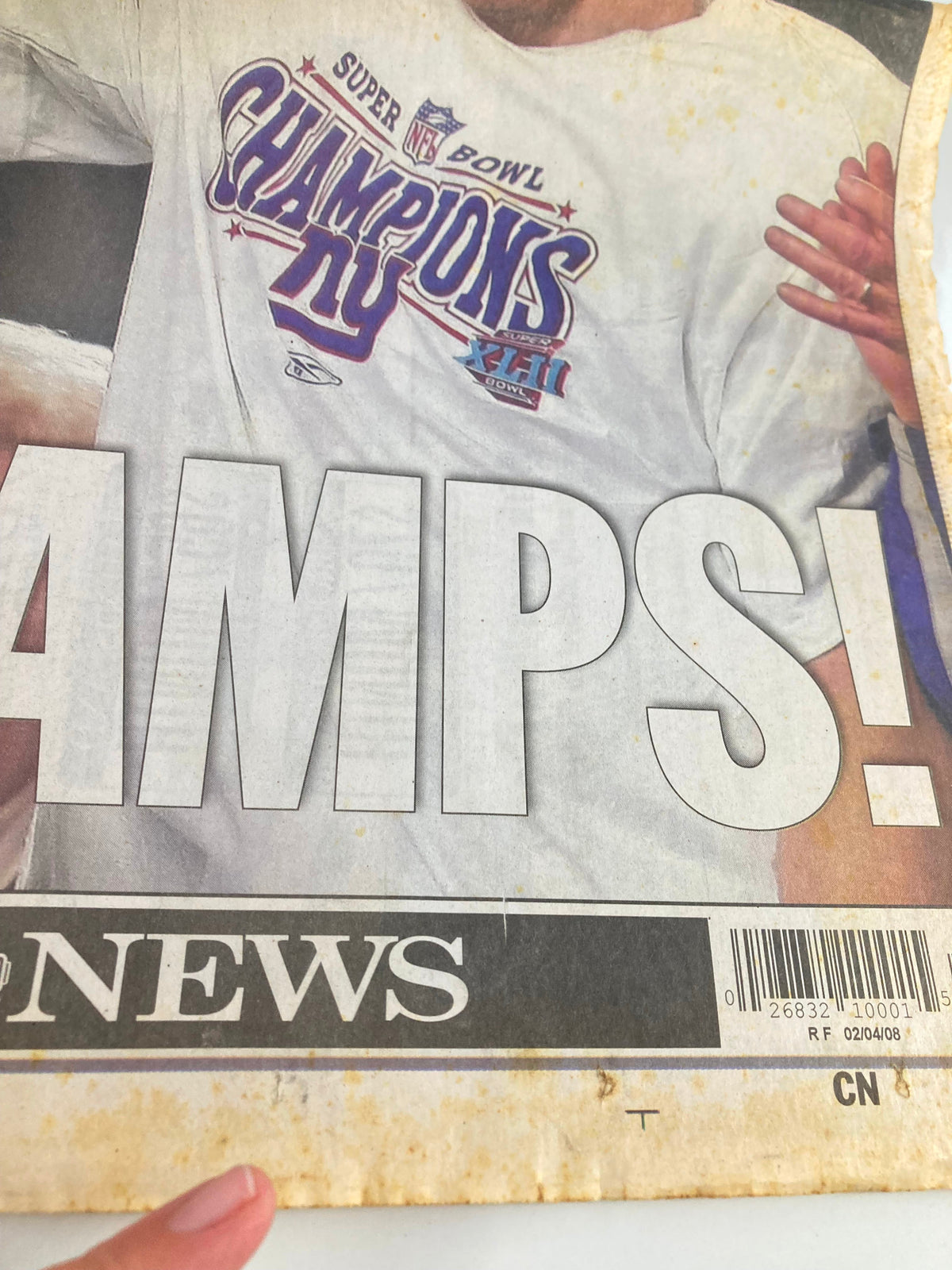 Close-up of the Daily News Newspaper February 4 2008 featuring the New York Giants Super Bowl Champions with a bold 'CHAMPIONS!' graphic and details of a player's celebration.