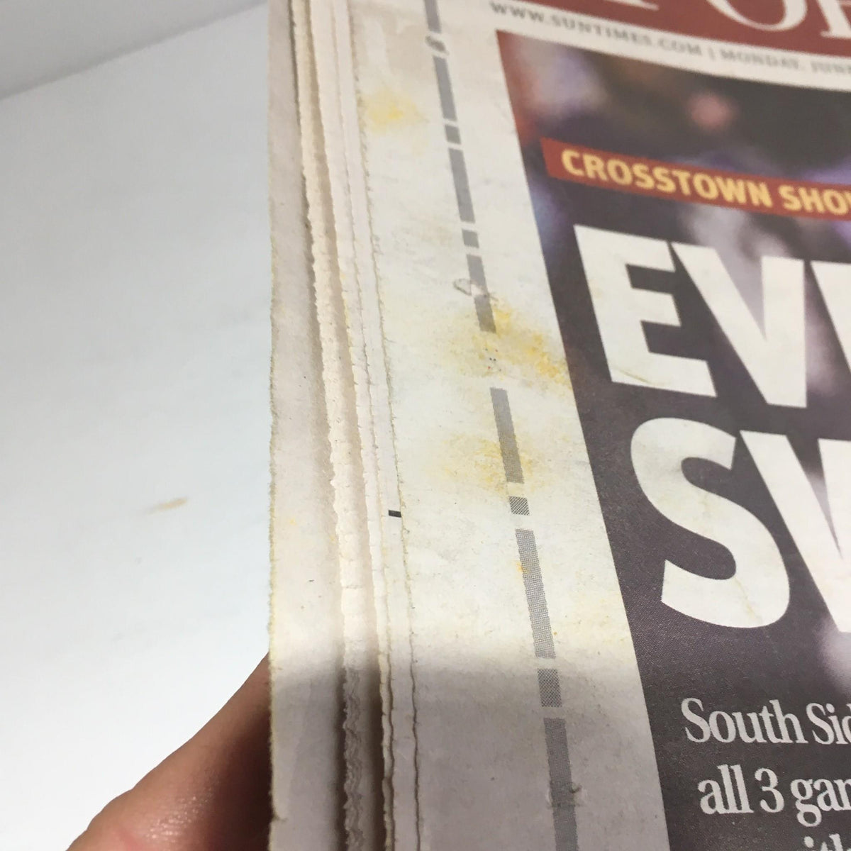 Close-up view of the edge of the Chicago Sun-Times newspaper, showing signs of aging and wear, indicative of its vintage condition.