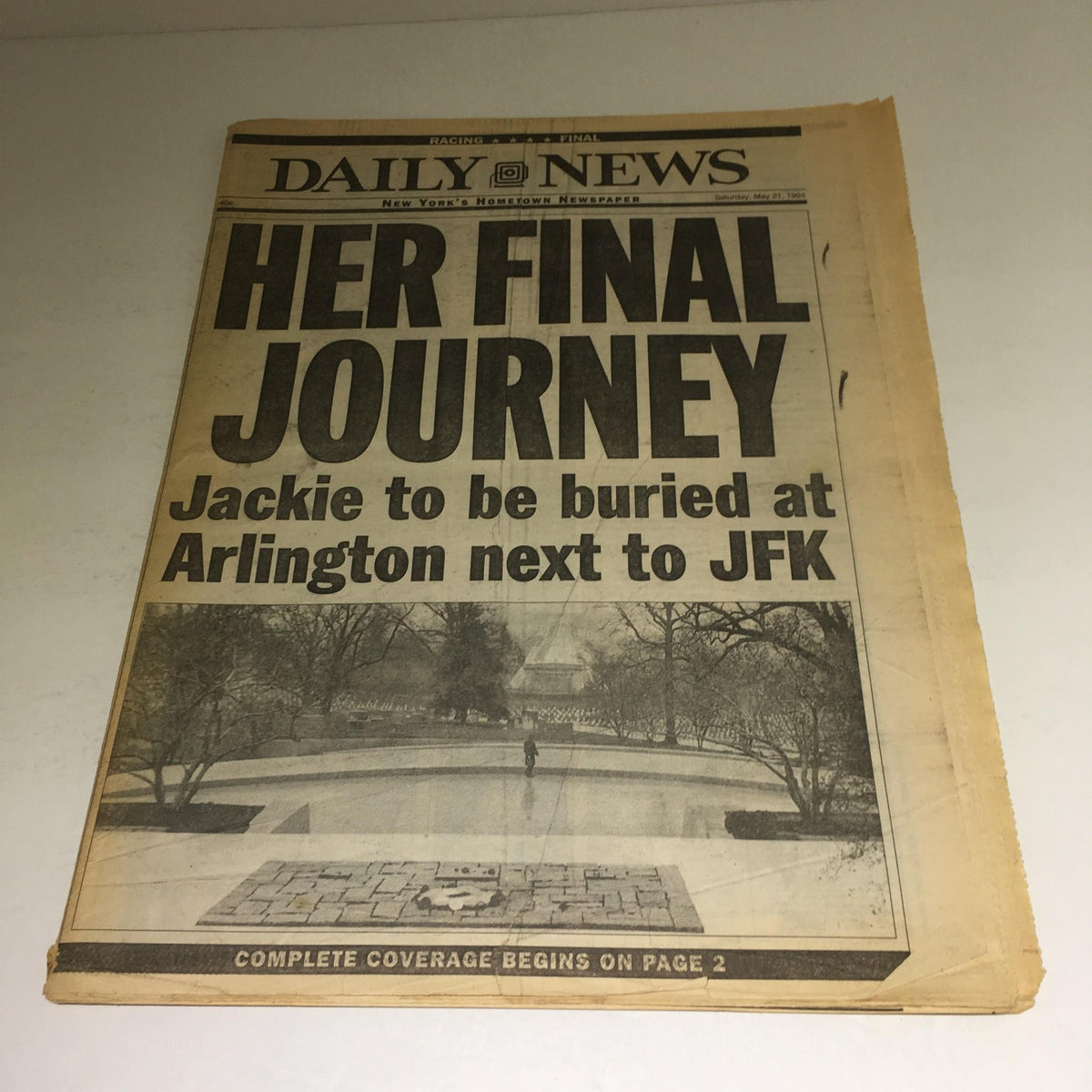 New York Daily News headline 'Her Final Journey: Jackie to be buried at Arlington next to JFK', featuring an image of Arlington Cemetery.
