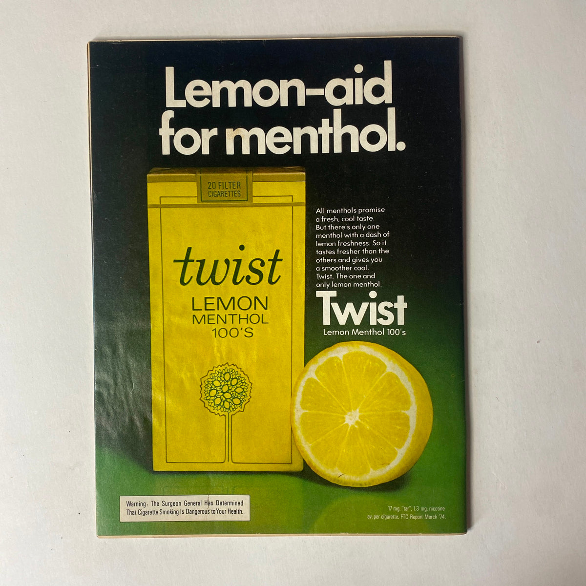 Advertisement for Lemon-Aid for menthol cigarettes featured in Time Magazine, emphasizing the freshness of Twist Lemon Menthol 100's. The design showcases a vibrant lemon illustration against a striking green background.