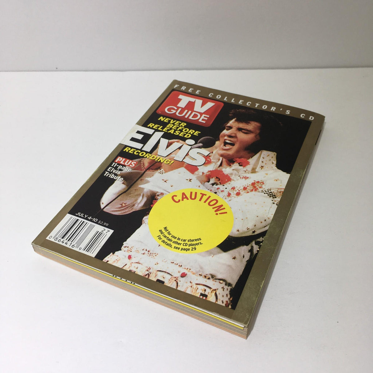 Front cover of the TV Guide July 4-10 2004 featuring Elvis Presley with the text 'First Ever Released Elvis Recordings!' and a caution sticker, showcasing Elvis in a dynamic pose.