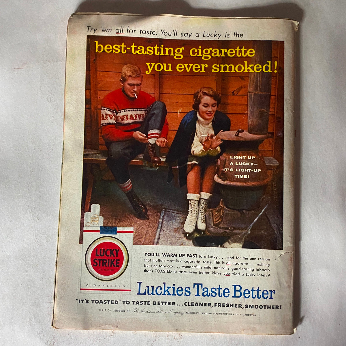 Vintage advertisement from the back cover of VTG Time Magazine February 11, 1957 showcasing a Lucky Strike cigarette ad with a couple in a cozy setting, emphasizing product appeal.