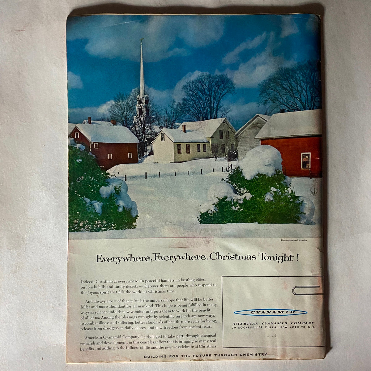Advertisement in VTG Time Magazine December 24, 1956, showcasing a winter landscape with a church and snow-covered homes, promoting a festive holiday message.