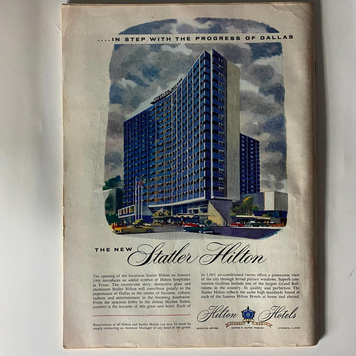 Advertisement in VTG Time Magazine January 23, 1956 for the new Statler Hilton, illustrating the luxurious hotel building with colorful design elements and vintage cars in the foreground.