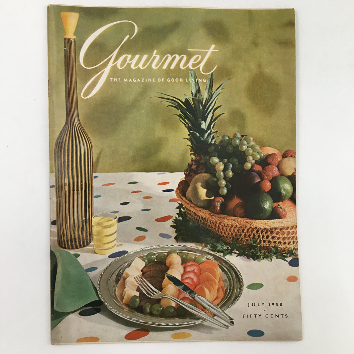 Gourmet Magazine July 1958 cover featuring a colorful table setting with fruits and a stylish design, capturing the essence of fine dining and summer culinary delights.