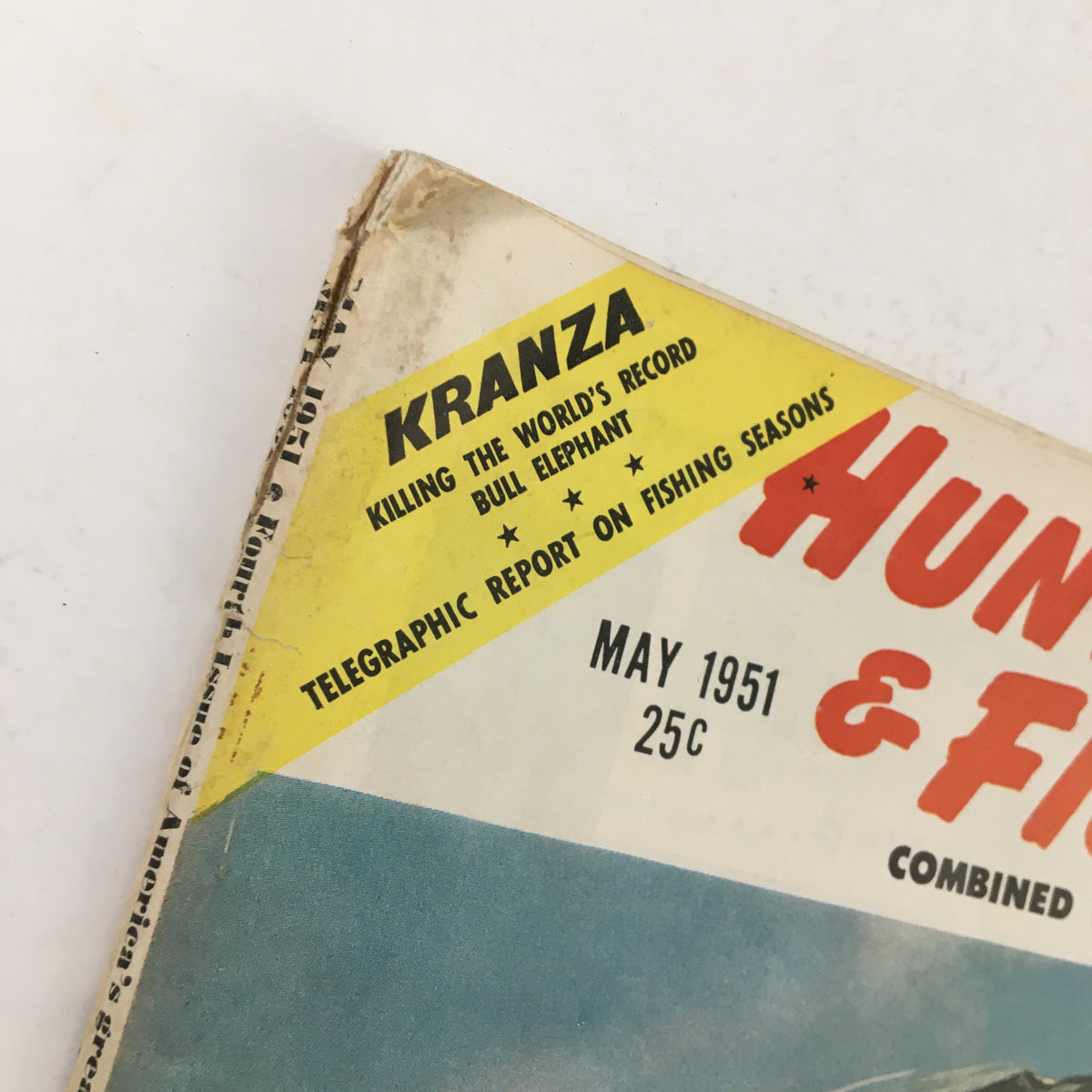 Close-up of the top corner of Hunting & Fishing Magazine May 1951 with the headline 'Killing The World's Record Bull Elephant' and details about fishing seasons.