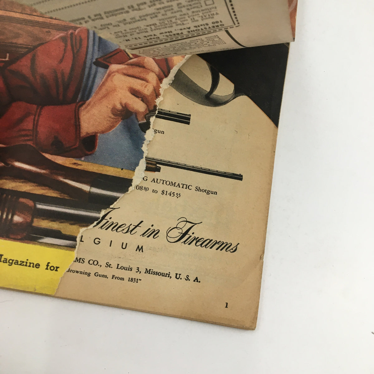 Close-up view of the torn edge of the Hunting & Fishing Magazine September 1950 cover page, showcasing details about firearms along with an address label, highlighting its vintage character.