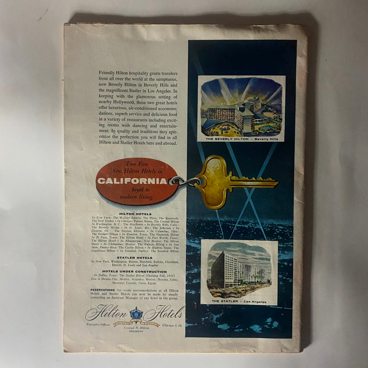 Vintage advertisement from a 1955 Time Magazine issue showcasing Hilton Hotels in California, featuring images of The Beverly Hilton and The Statler Hotel in Los Angeles, along with a promotional key tag.