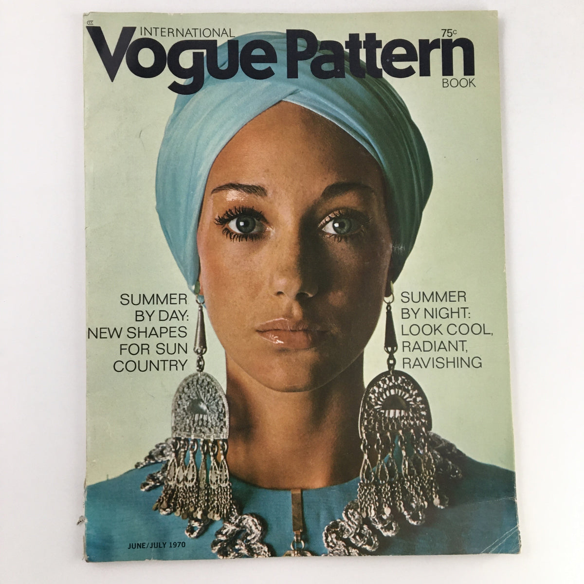 Cover of International Vogue Pattern Book June 1970 showcasing a model with a blue headscarf and ornate earrings, featuring the title 'Summer by Day: New Shapes for Sun Country.'