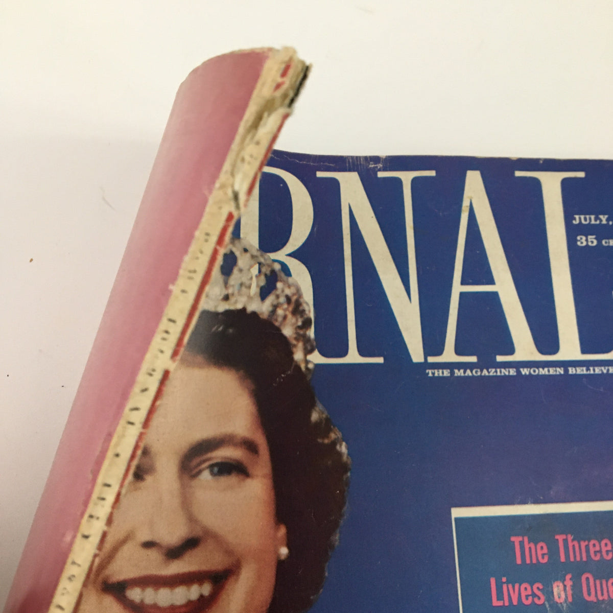 Side view of the Ladies' Home Journal Magazine July 1961, showcasing the cover of 'The Three Lives of Queen Elizabeth II'. The spine has slight wear and vintage character.