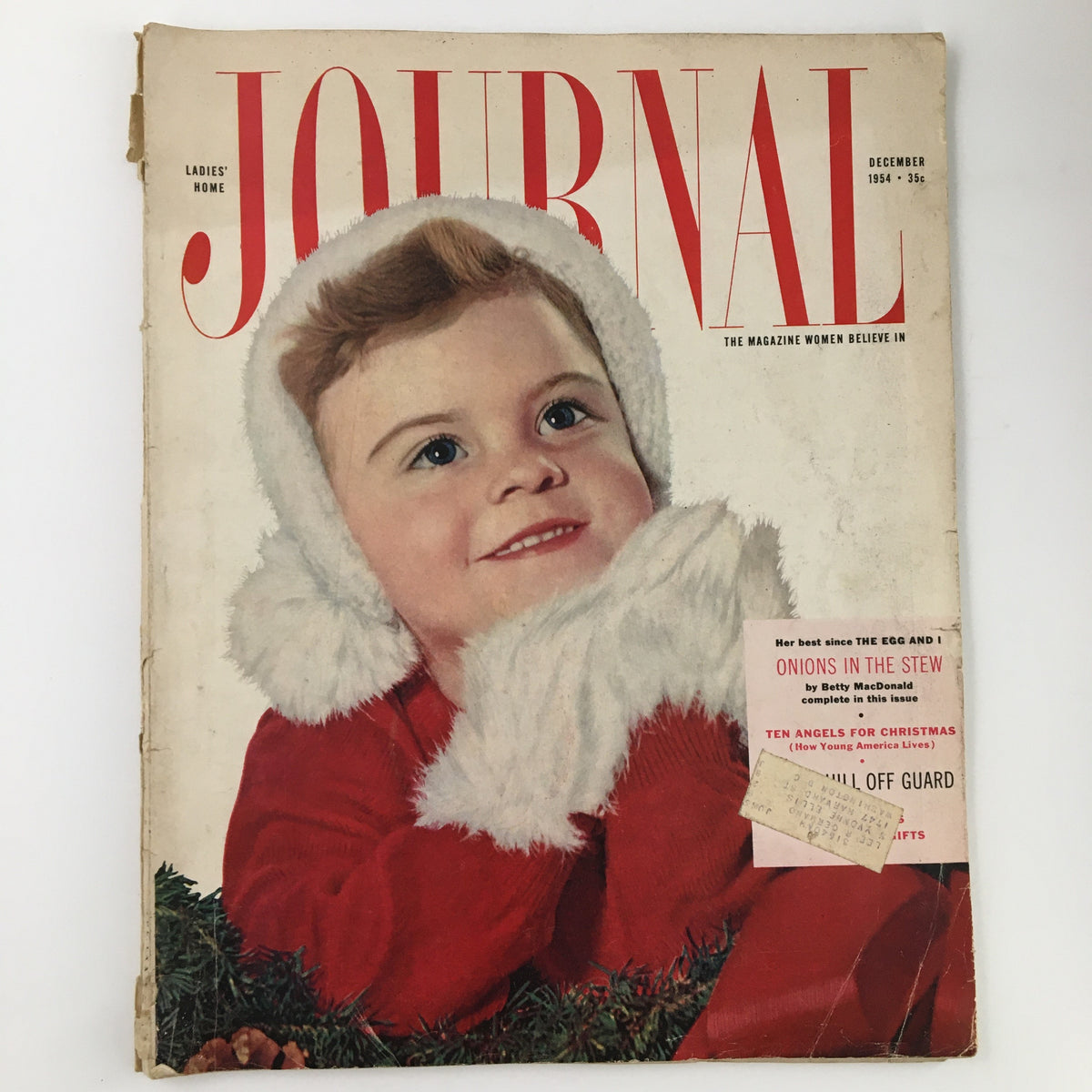 Cover of Ladies' Home Journal Magazine December 1954 featuring a cheerful child in winter attire, capturing the essence of the festive season and the theme 'The Night Before The Wedding'.