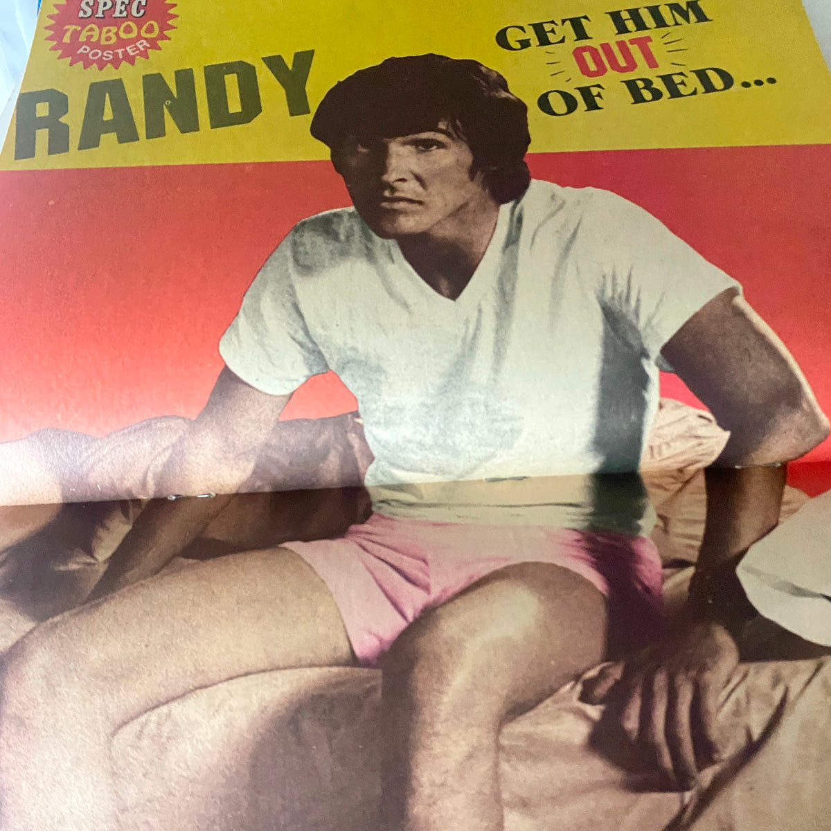 VTG 16 SPEC Magazine October 1974, featuring a prominent image of a young man with dark hair sitting on a bed in a white t-shirt and pink shorts, accompanied by the text 'GET HIM OUT OF BED...' and labeled as a SPEC TABOO poster.