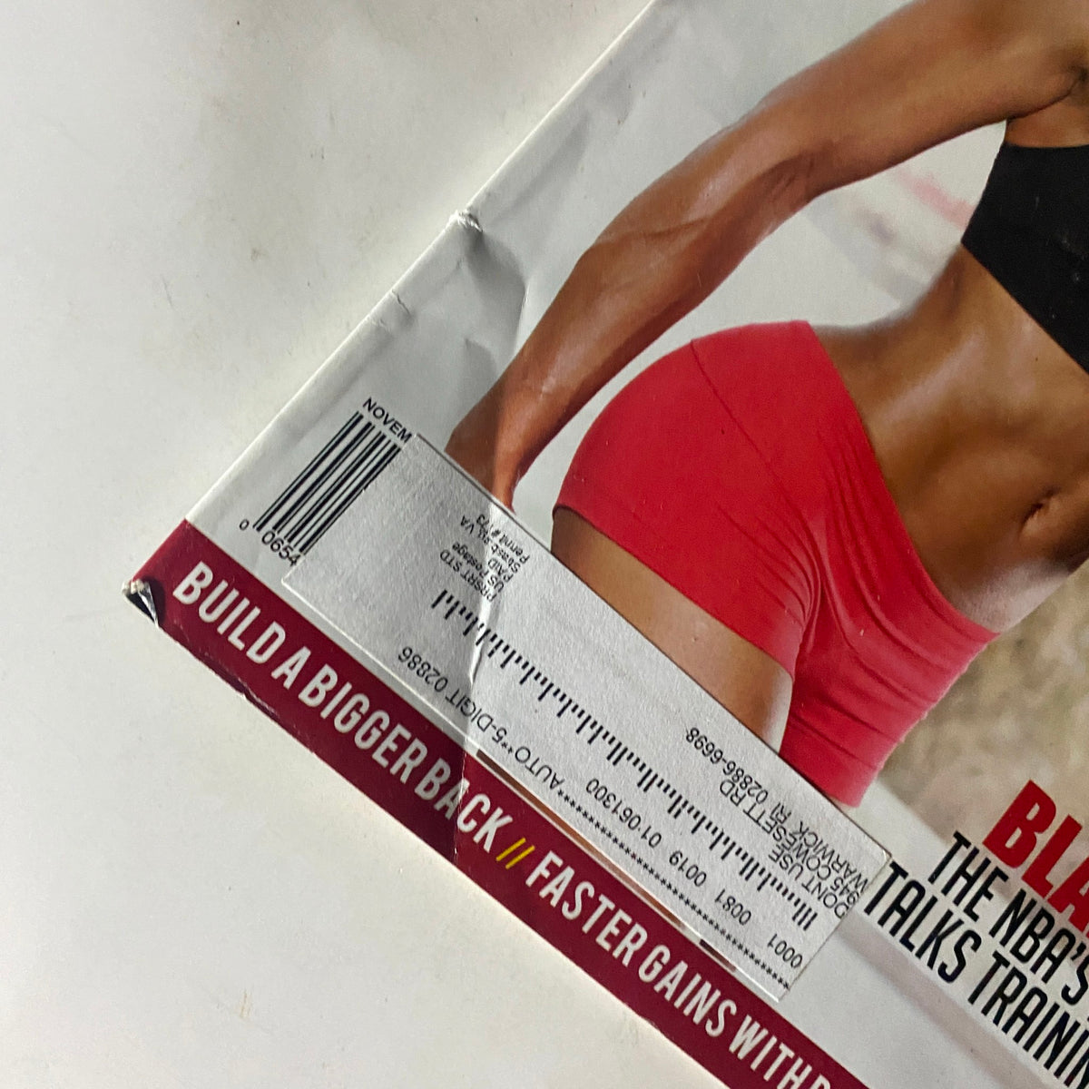 Close-up of the edge of Muscle & Performance Magazine November 2009, highlighting details of the magazine's condition, including wear typical for its age.