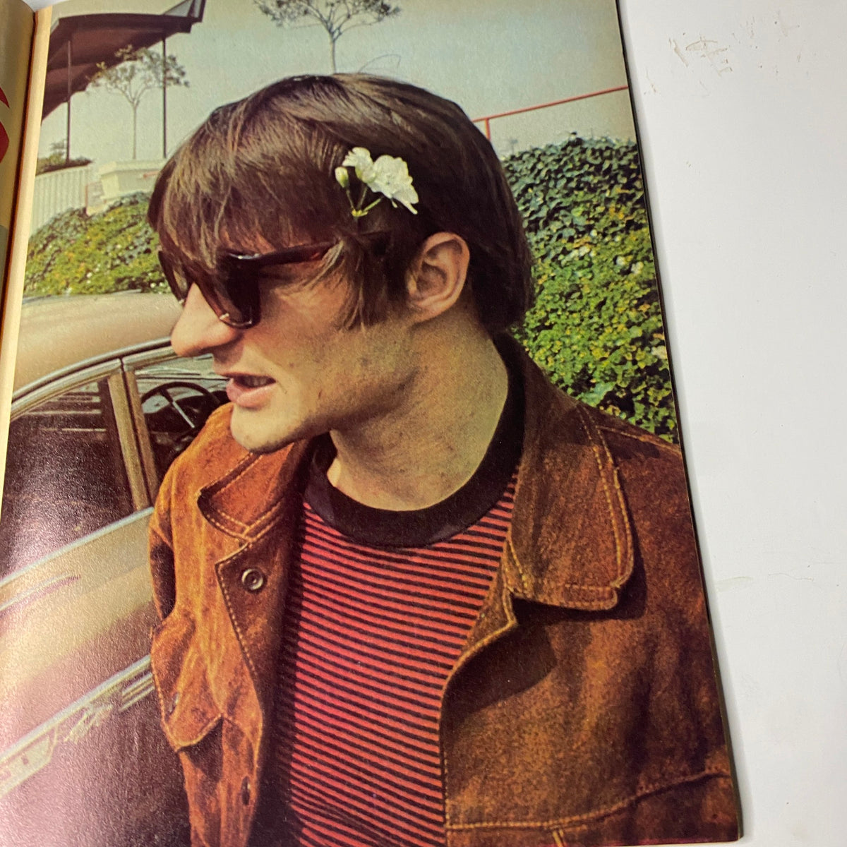 Image of a young man with sunglasses and a flower in his hair from Teen Screen Magazine February 1968, representing the 1960s counterculture.